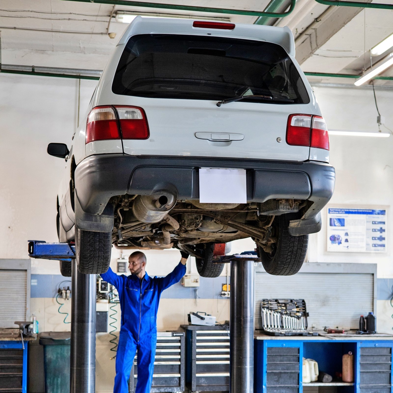 Mechanic inspecting a car on a hoist